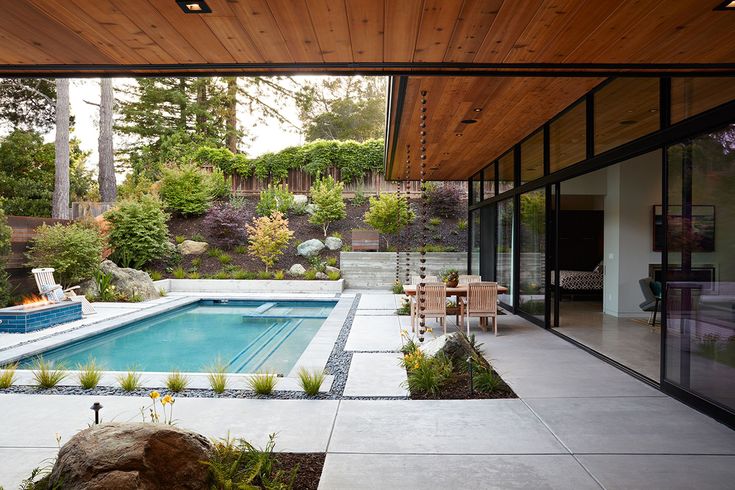 an outdoor swimming pool surrounded by rocks and plants