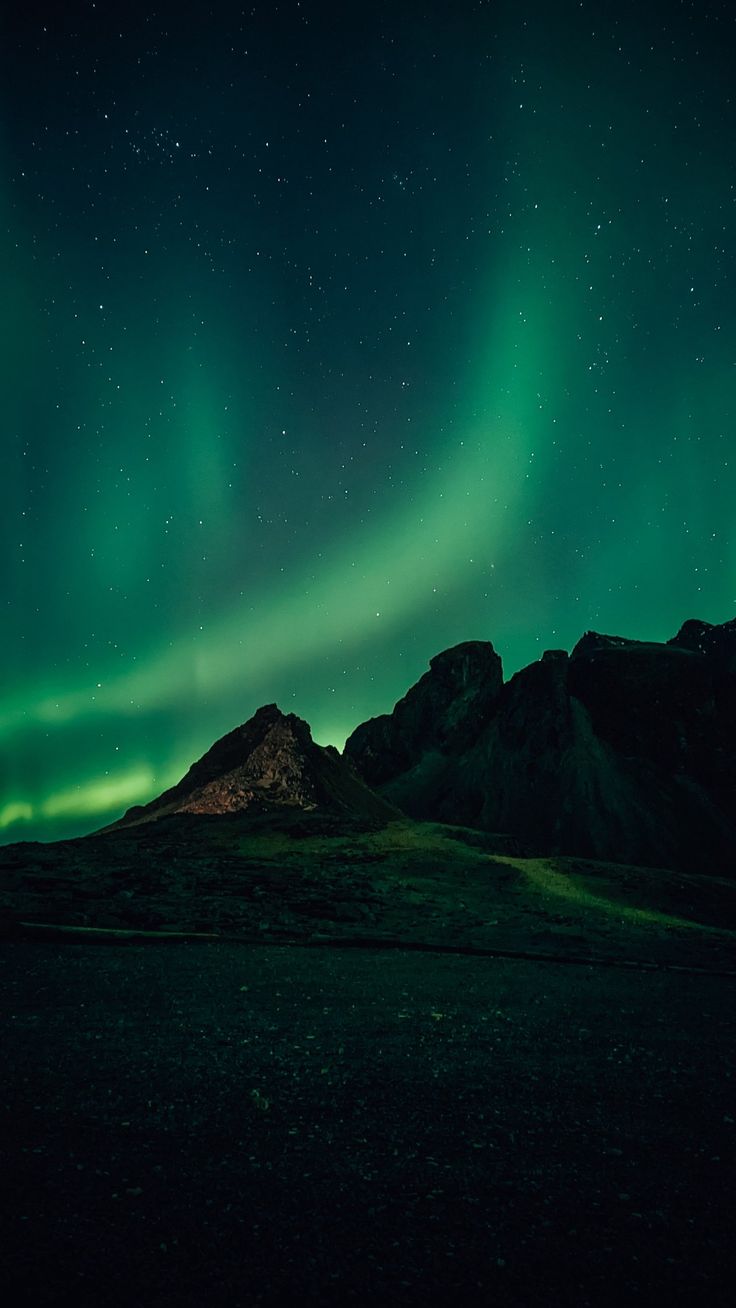 the northern lights shine brightly in the sky above mountains