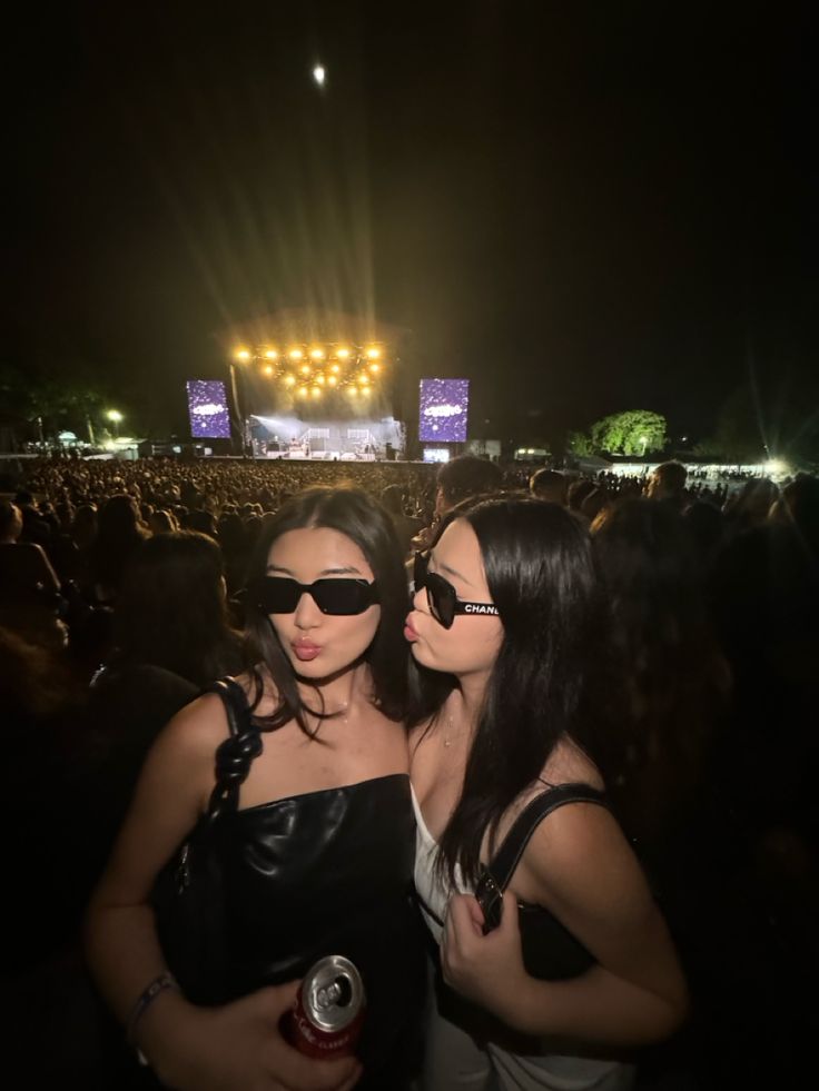 two women standing next to each other at a concert