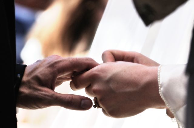 the hands of two people holding each other's wedding rings in front of them