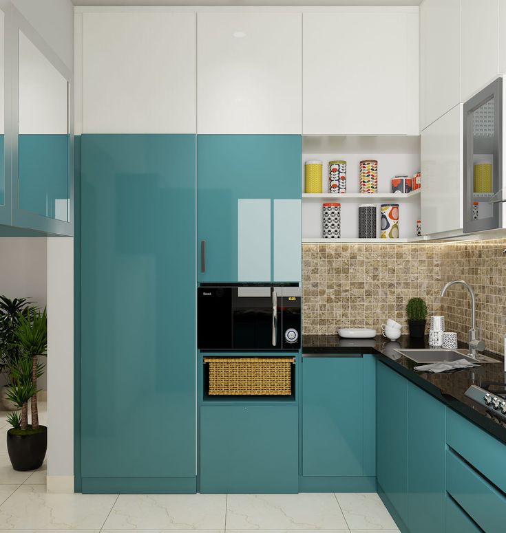 a kitchen with blue and white cabinets, black counter tops, and a potted plant in the corner