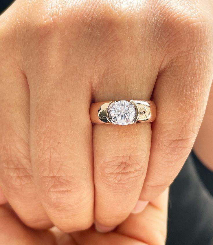 a woman's hand with a diamond ring on her finger, showing the middle finger