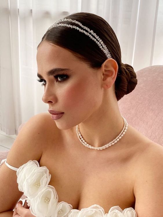 a woman in a wedding dress wearing a tiara with flowers on the headband