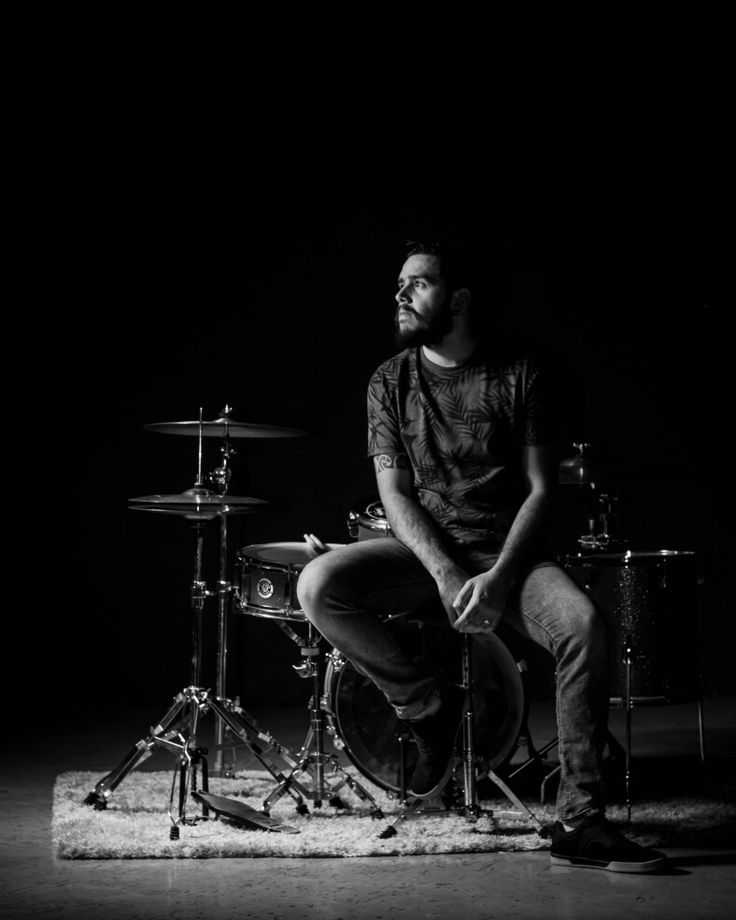 a man sitting on top of a drum set next to a pair of cymbals