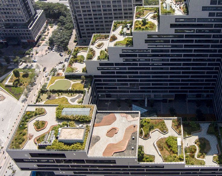 an aerial view of some buildings with plants growing on the roof and in the middle