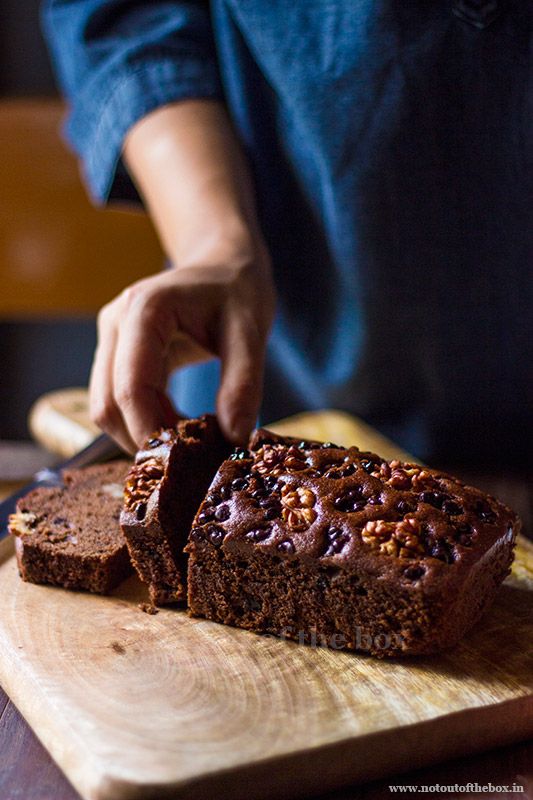 a person cutting up some brownies on top of a wooden board with a knife