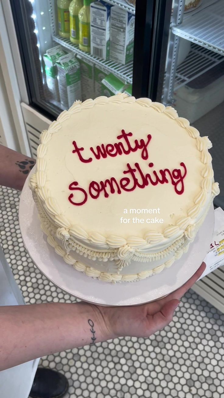 a cake with the words twenty something written on it is being held by a woman