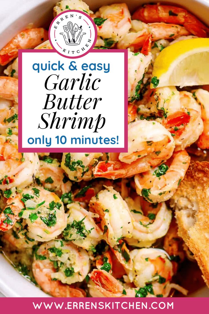 a bowl filled with garlic butter shrimp next to bread and lemon wedges on the side