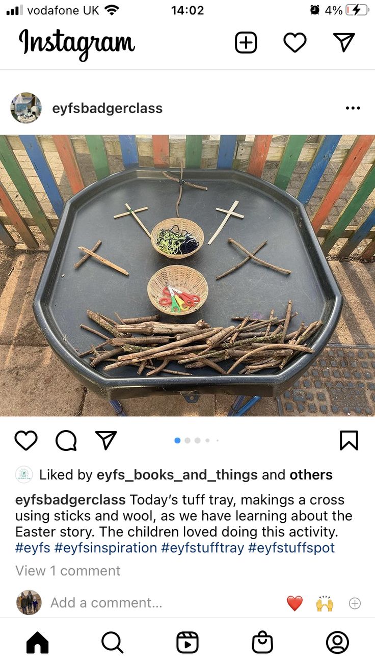 a tray with sticks and spoons on it sitting in front of a colorful fence