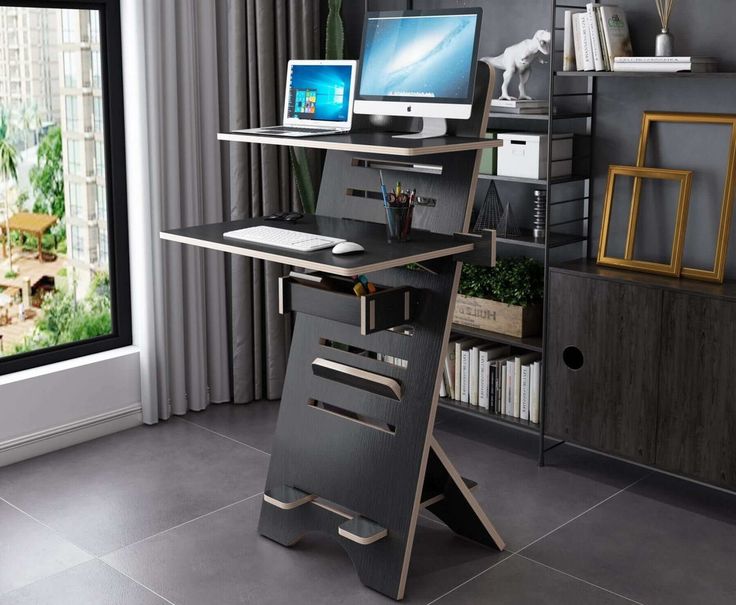 a computer desk sitting in front of a window