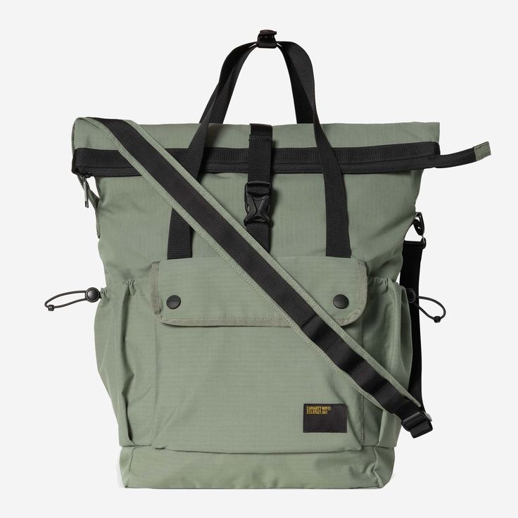 a large green bag with black straps on the front and side pockets, sitting against a white background