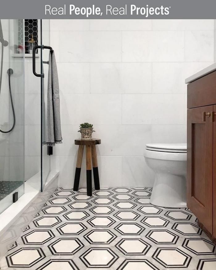 a white bathroom with black and white floor tiles on the walls, toilet and shower