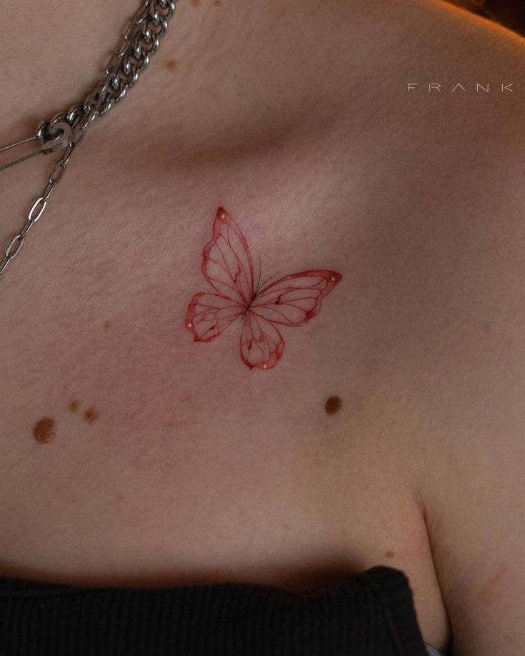 a close up of a person's chest with a butterfly tattoo on the chest