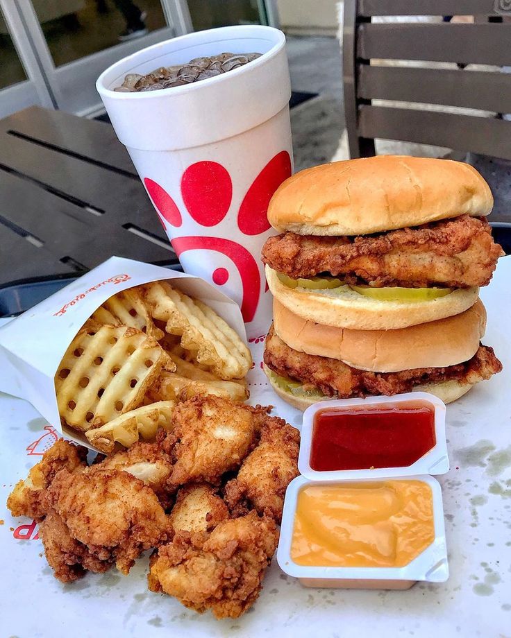 fried chicken, waffle fries and coleslaw on a table with a cup of coffee