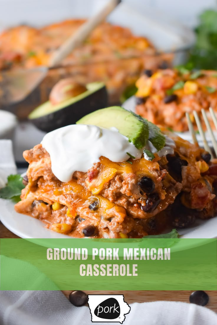 a white plate topped with mexican casserole covered in sour cream and avocado