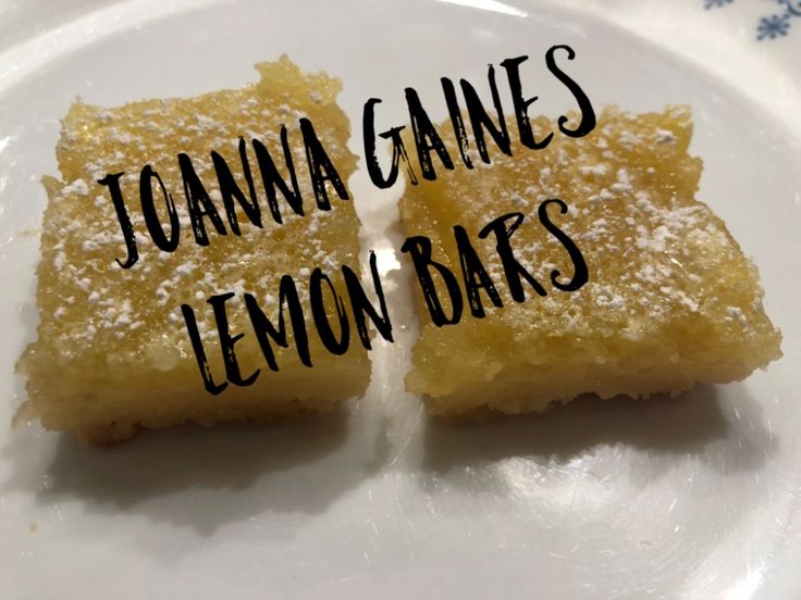 two pieces of lemon bars sitting on top of a white plate next to each other