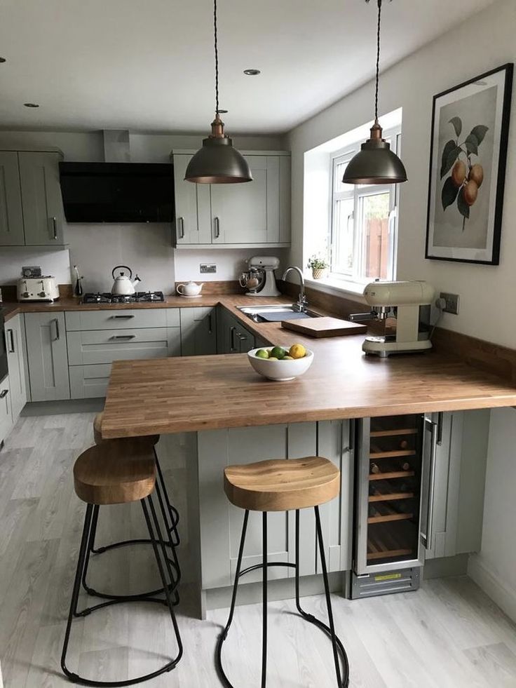 a kitchen with two stools at the island