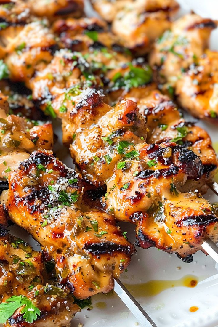 chicken skewers with herbs and parmesan on a white plate