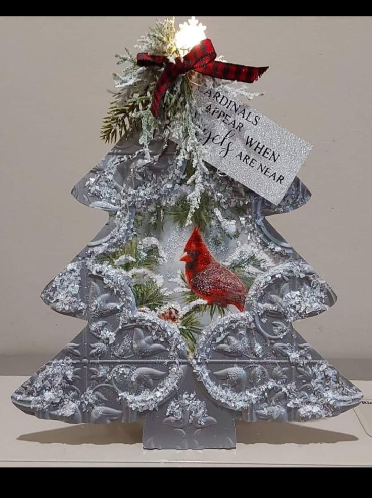 a metal christmas tree with a cardinal on it