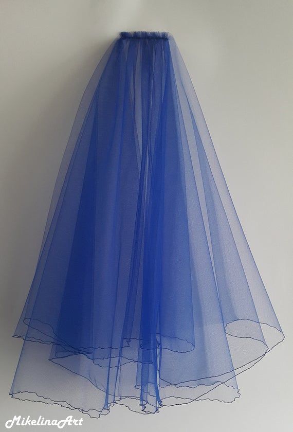 a blue tulle skirt hanging up against a white wall with the bottom half down