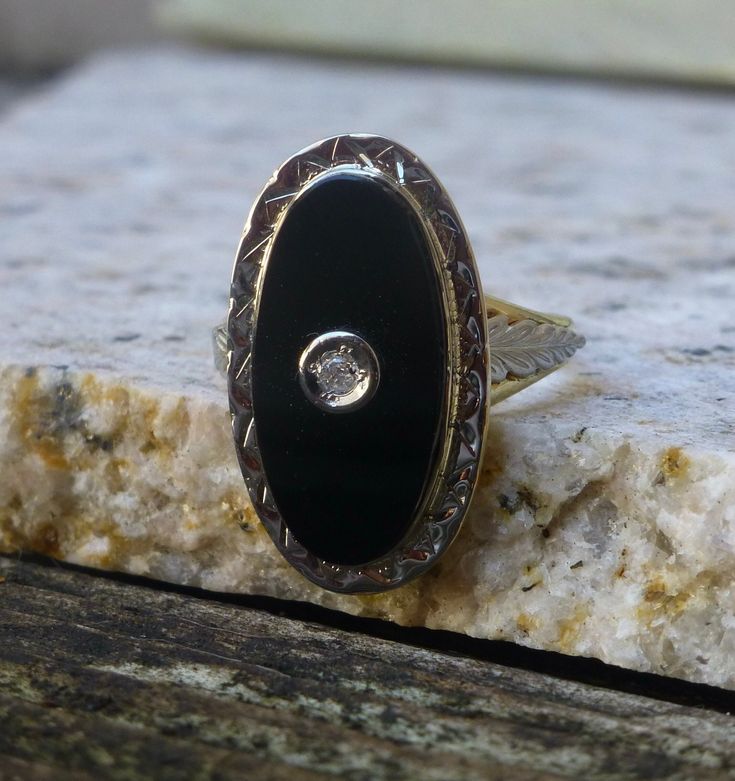 Metal: Solid 14k Yellow and White Gold Stone: 9x18 mm Onyx and a 2mm Diamond Size: 5 Weight: 3.7 grams Era: 1930's This classy ring is white gold on the top and yellow gold on the bottom. Intricately engraved white gold leaves adorn each side of the ring. The oval onyx has a small diamond set in white gold in the center. All of the engraving is still crisp and detailed after all these years. The stone is in very good condition with no eye visible flaws. The interior of the band is stamped with the 14k gold purity stamp. The ring has been professionally cleaned and polished and is ready to wear.  To view our other listings of fine jewelry click here, https://www.etsy.com/shop/seafarevintage?ref=hdr_shop_menu To help make your decision easier, I am always more than happy to take additional p Vintage Yellow Gold Onyx Rings, Yellow Gold Onyx Signet Ring With Black Enamel, Luxury Onyx Signet Ring With Polished Finish, Vintage Onyx Oval Cabochon Jewelry, Antique Onyx Rings With Polished Finish, Gold Art Deco, Gold Art, Onyx Ring, Diamond Sizes