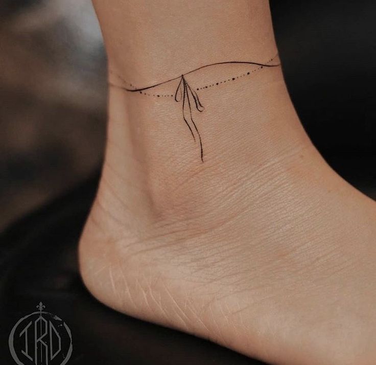 a woman's foot with a small tattoo on the side of her left ankle