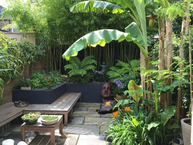 an outdoor garden with wooden benches and plants