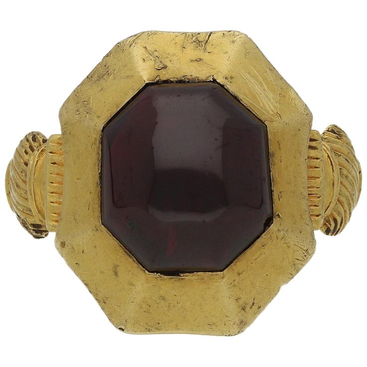 Medieval garnet cabochon ring. Set to centre with a single octagonal cabochon natural unenhanced garnet in a closed back rubover setting with an approximate weight of 8.00 carats, to an octagonal 'pie-dish' bezel design, leading to intricately carved shoulders and flowing through to a solid shank. Tested yellow gold, circa 1200-1400 century. Accompanied by documentation from the Portable Antiquities Scheme stating that this ring was found whilst metal detecting cultivated land in the Kingswood a Ancient Rings, Hand Engraved Rings, Spessartite Garnet, Engraved Plaque, Buckle Ring, Gem Diamonds, Gold Belts, Victorian Rings, Gold Signet Ring