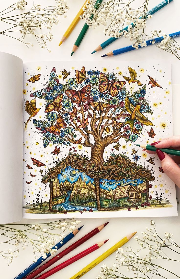 someone is drawing a tree with colored pencils