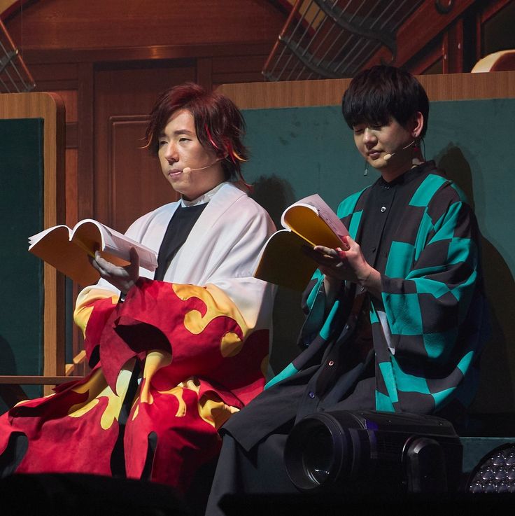 two young men dressed in traditional japanese garb, one holding a fan and the other sitting down