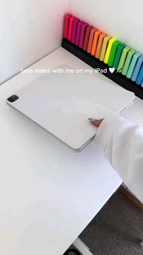 a person using a mouse pad on top of a white desk with colored crayons in the background