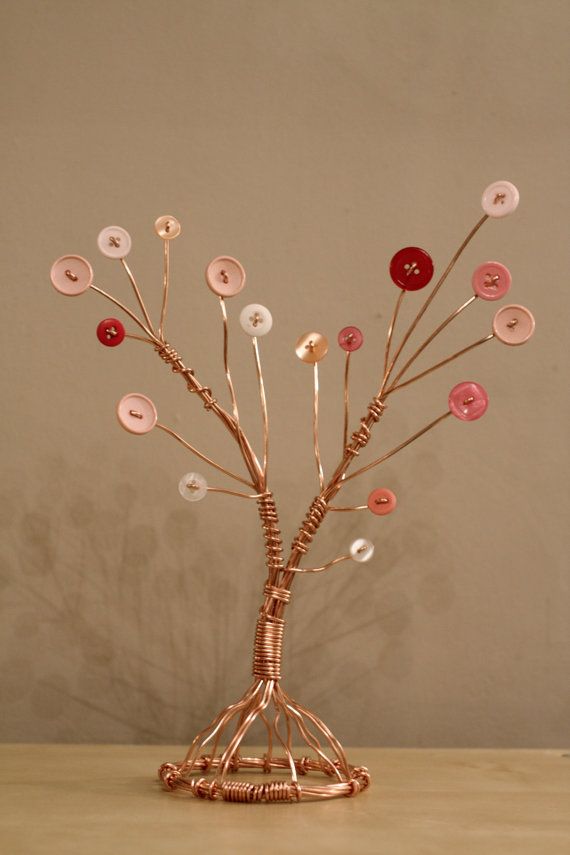 a vase filled with lots of pink and white flowers on top of a wooden table