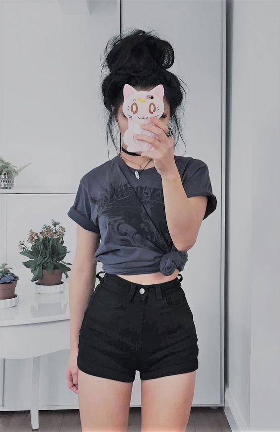 a woman taking a selfie with her cell phone in front of her face and wearing black shorts