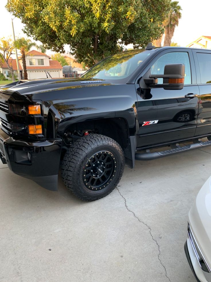 a large black truck parked in a driveway