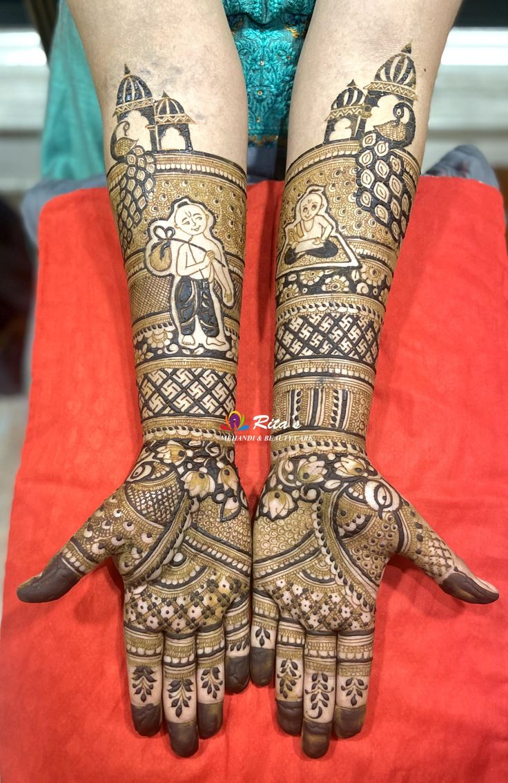 two hands with henna tattoos on them sitting next to each other in front of a red chair