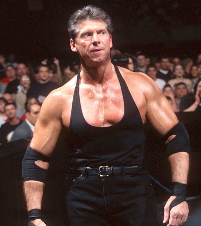 an image of a man in the middle of a wrestling ring with his hands on his hips