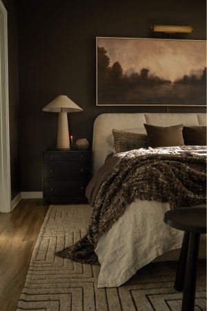 a bedroom with brown walls and white bedding