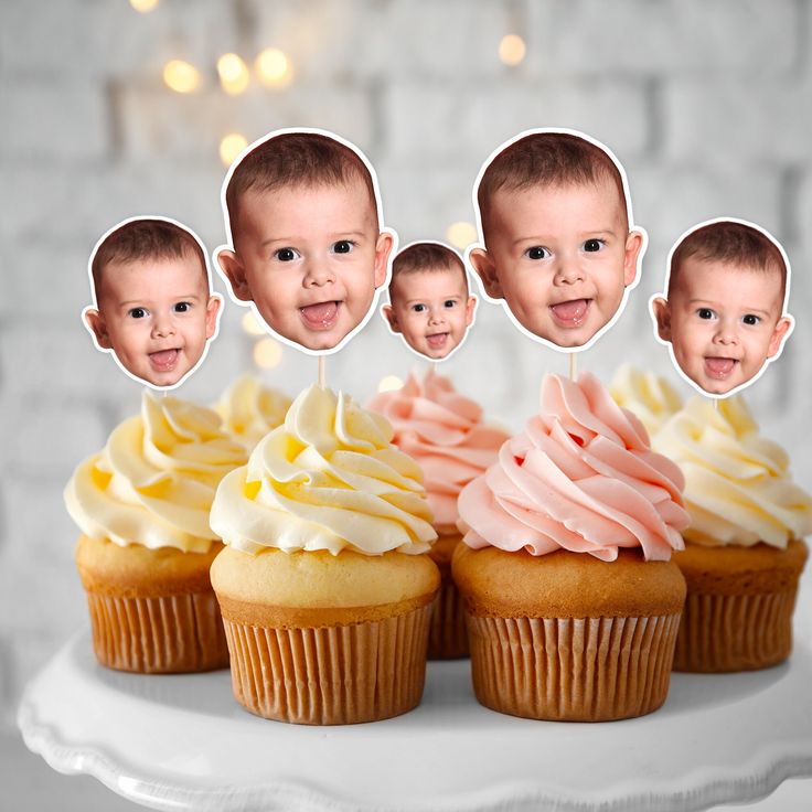 the cupcakes have been cut out to look like babies'faces and are decorated with icing