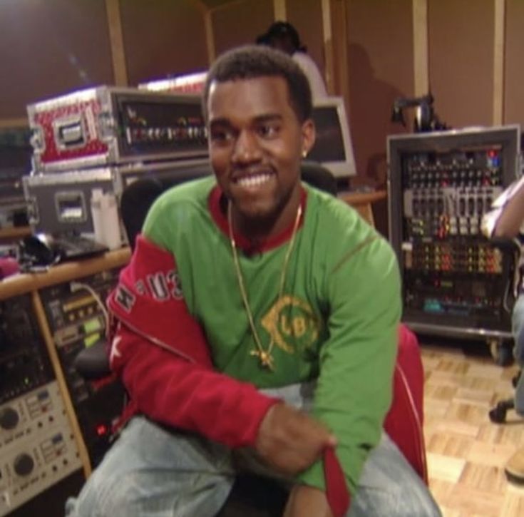 a man sitting on top of a wooden floor in front of a recording equipment set