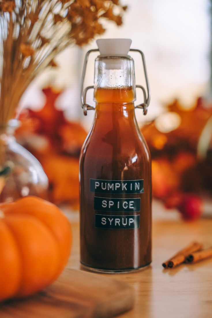 a bottle of pumpkin spice syrup sitting on top of a wooden table