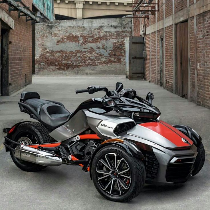 an orange and silver motorcycle parked in front of a brick building