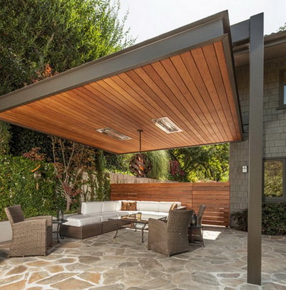 a covered patio with furniture and trees in the background