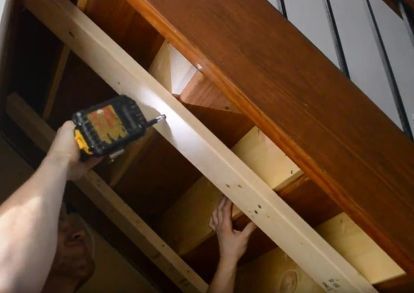 a person is holding a paintbrush in their hand and painting the bottom of stairs