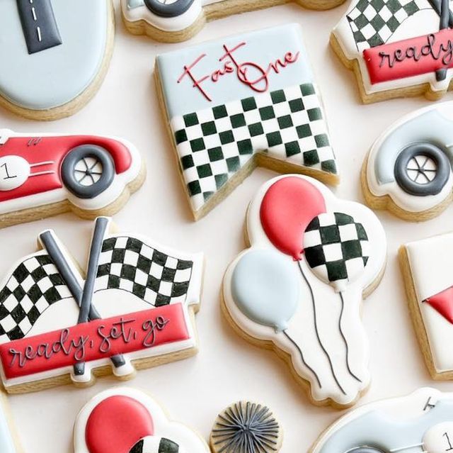 decorated cookies are arranged on a table with race flags and cars in the background,