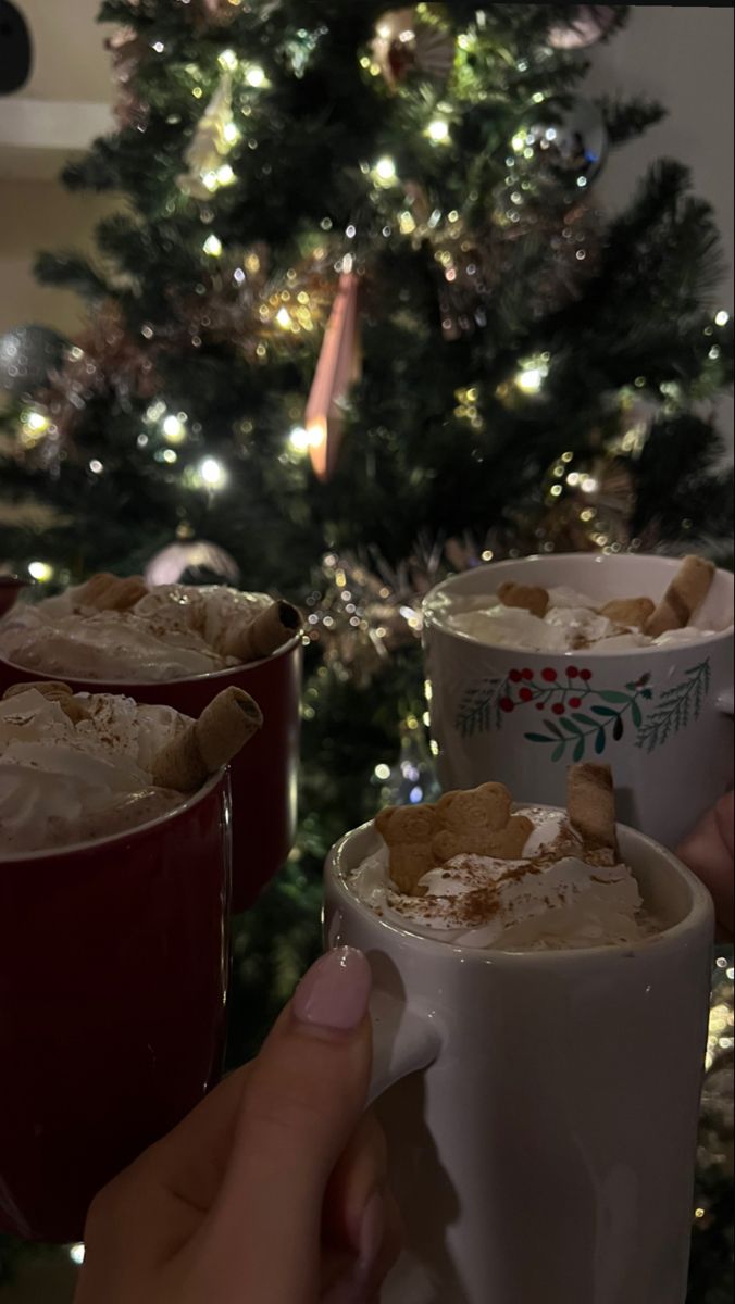 three cups filled with food next to a christmas tree