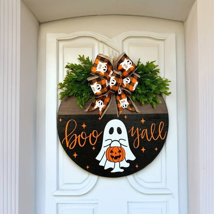 a decorated halloween door hanger with boo's on it