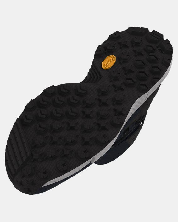 the sole of a pair of black and white shoes with yellow accents on top of it