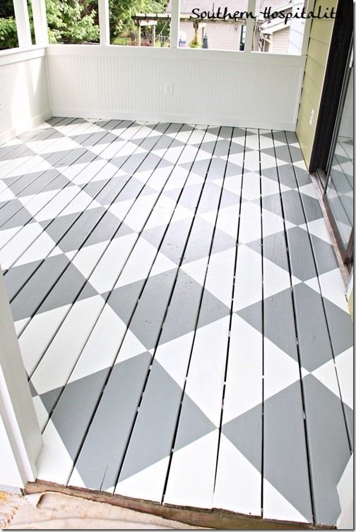 a porch with white and gray tiles on it