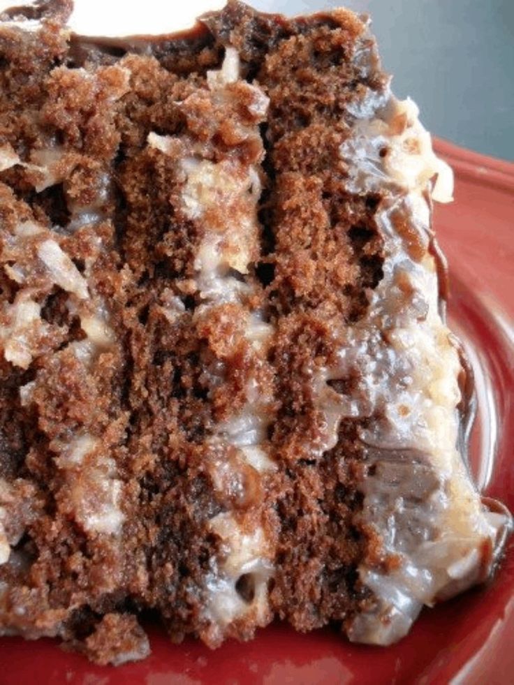 a close up of a piece of cake on a plate with icing and nuts