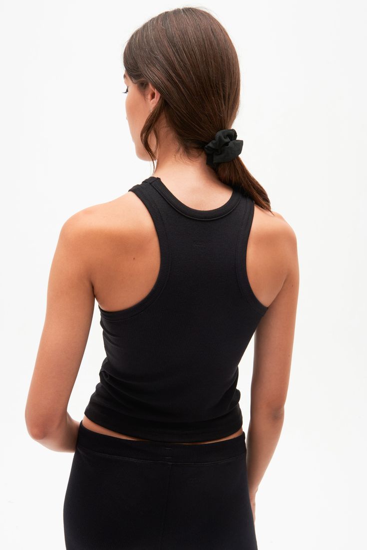 A high racer front and back neckline add a bit of sophistication to our classic tank. Super soft baby rib fabric to hug your body and layer effortlessly. BEST FOR: running, yoga, CrossFit, barre, Pilates, spin class and gym workouts. Model is 5'10" and wears a size small. NEW LONGER LENGTH Ribbed Stretch Racerback Activewear, Black Seamless T-back Tank Top, Black Yoga Tank Top, Black Ribbed Racerback Tank Top, Fitted Black Tank Top For Yoga, Black Fitted Tank Top For Yoga, Sporty High Stretch Ribbed Tank Top, Black High Stretch Tank Top For Yoga, Compressive Black Racerback Tank Top